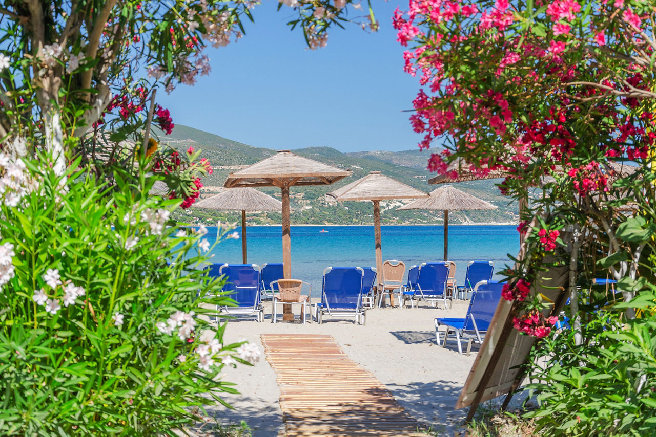 Picturesque sandy beach in Alykanas full of beautiful flowers and plants.