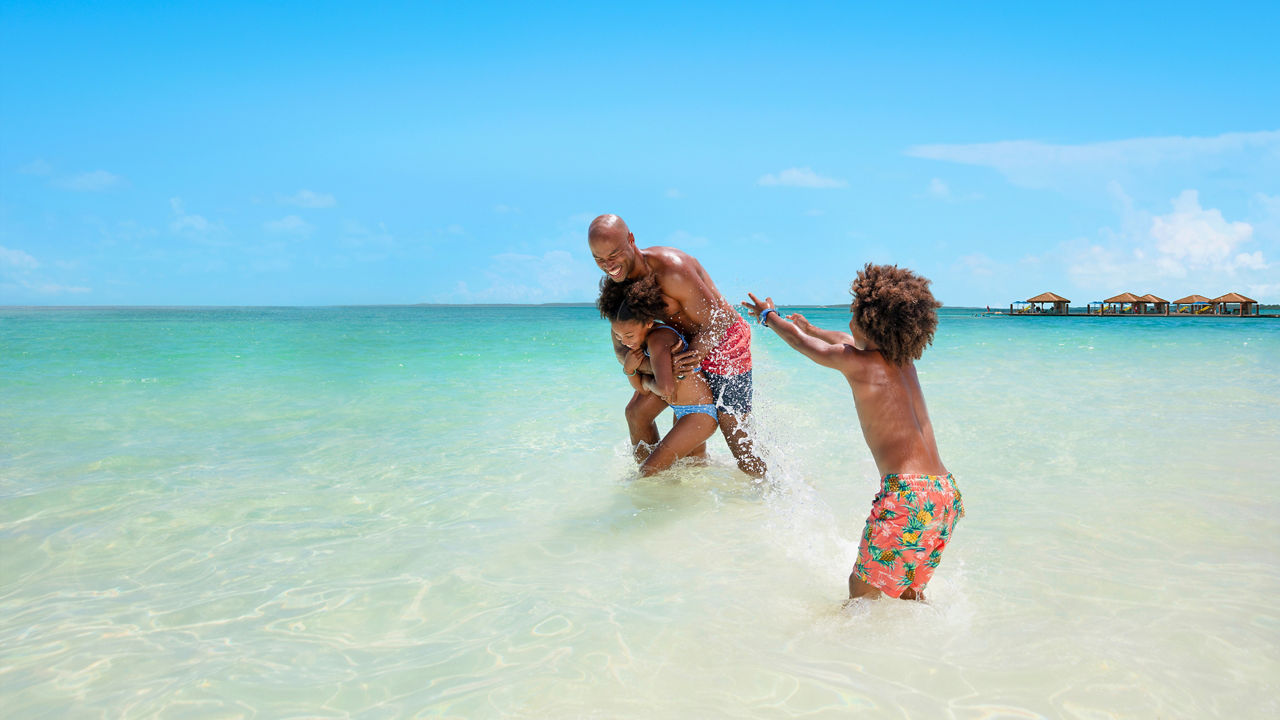 Dad and sons playing at Cococay Beach HP Jumbotron 1920 1080 FAM NF 2x
