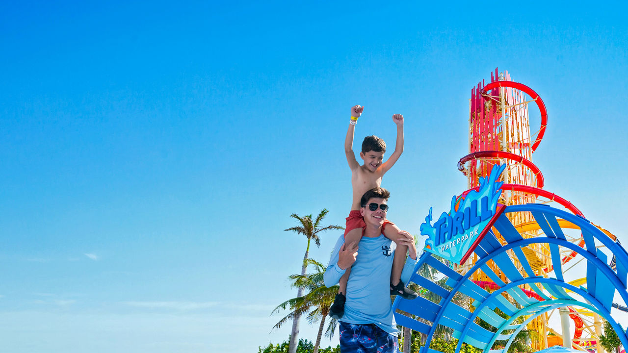 Man carrying a kid on the shoulders at thrill waterpark entrance