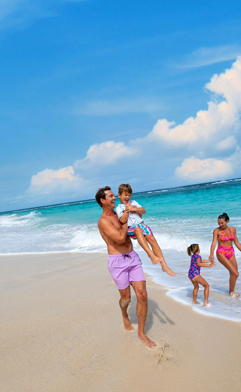Family playing soccer on the beach at Chill Beach at Royal Beach Club Paradise Island