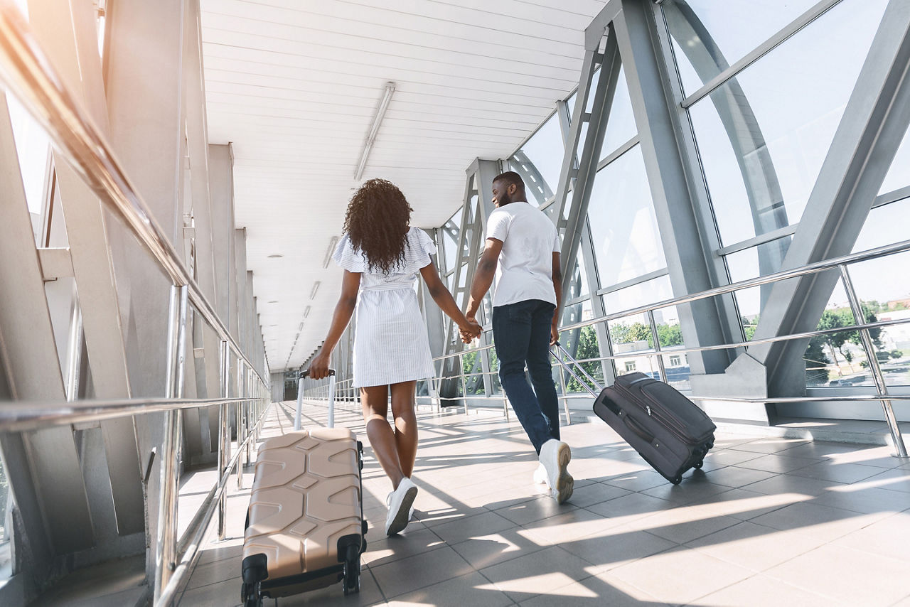 Newly Wed Couple Wallking at the Airport with Luggages
