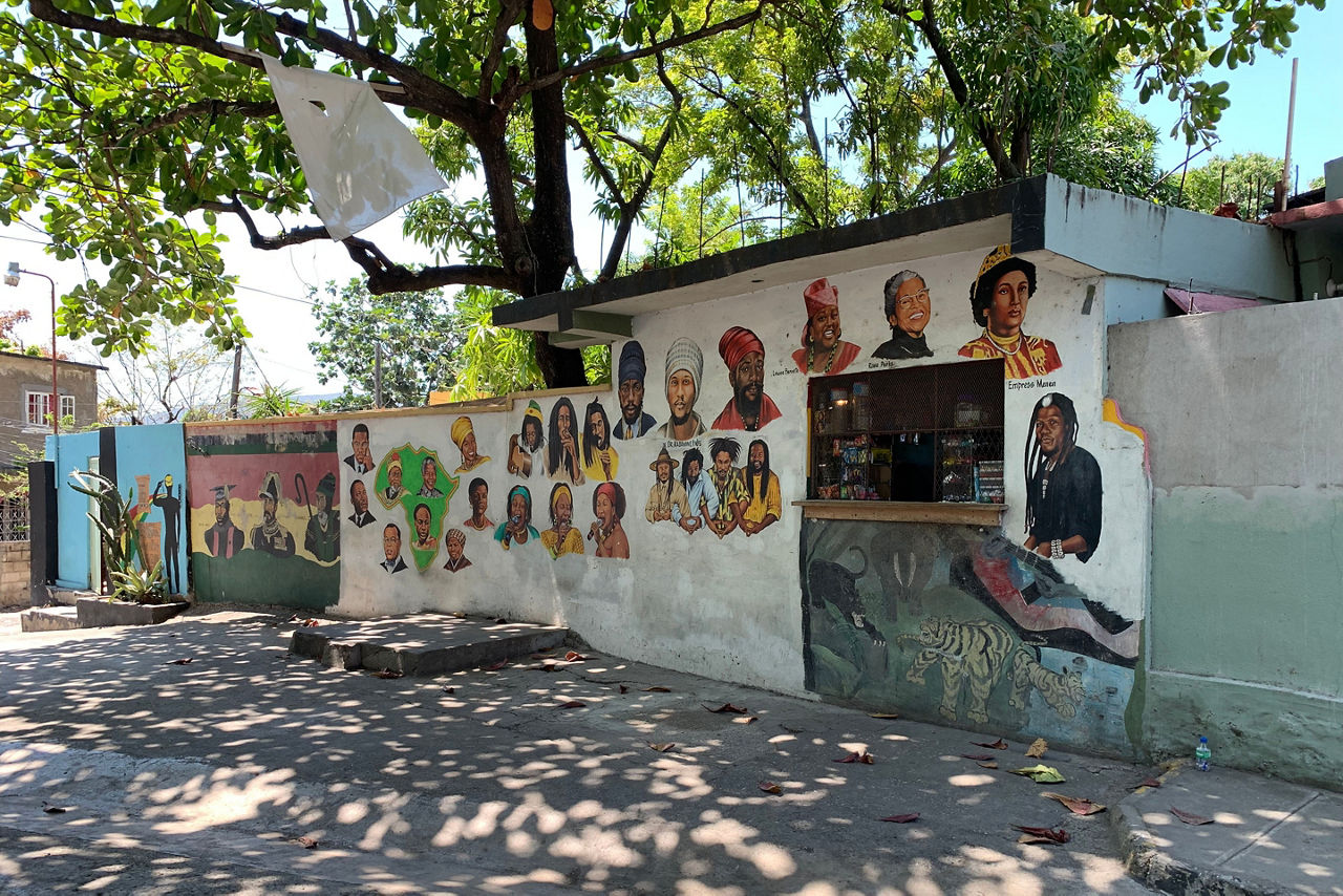 Mural of Jamaican singers and cultural icons on shop wall