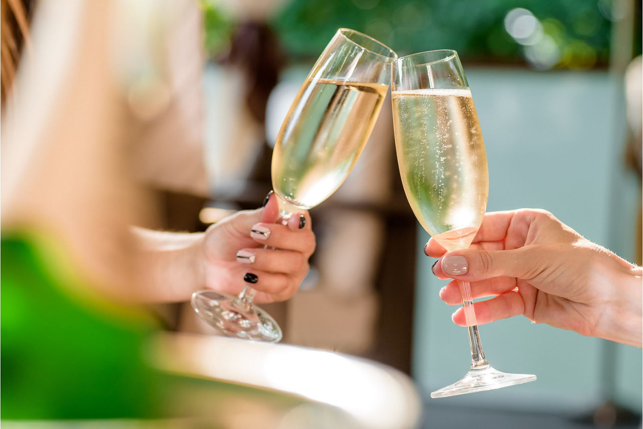 Woman Cheering with Champagne Glasses at Bubbles Champagne Bar