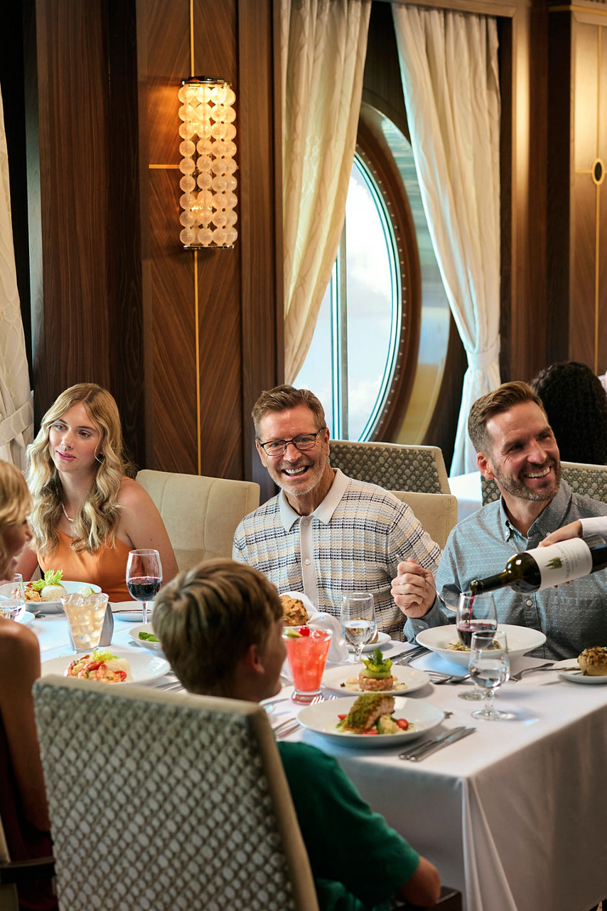 Family dining at  Main Dining Room while being poured wine by server