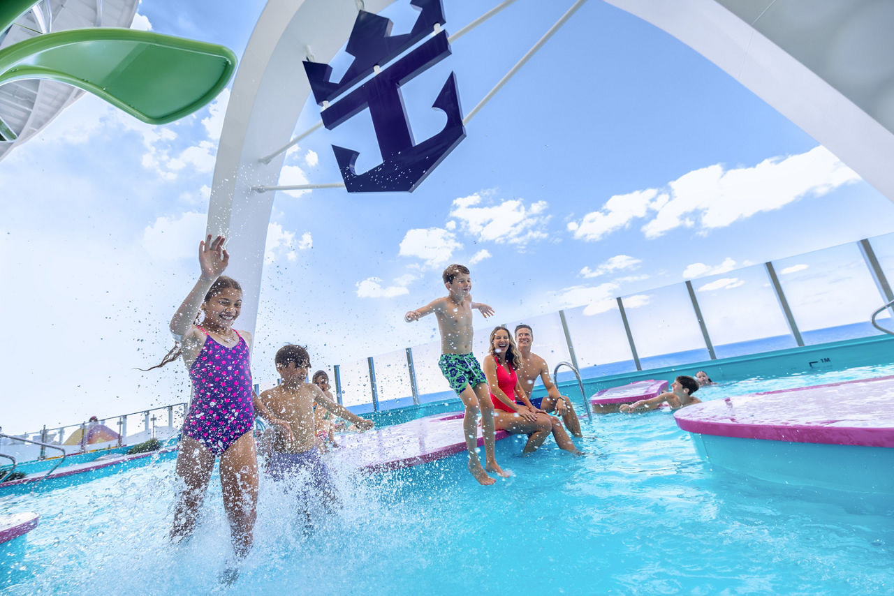 family splashing jumping waters edge pool star of the seas