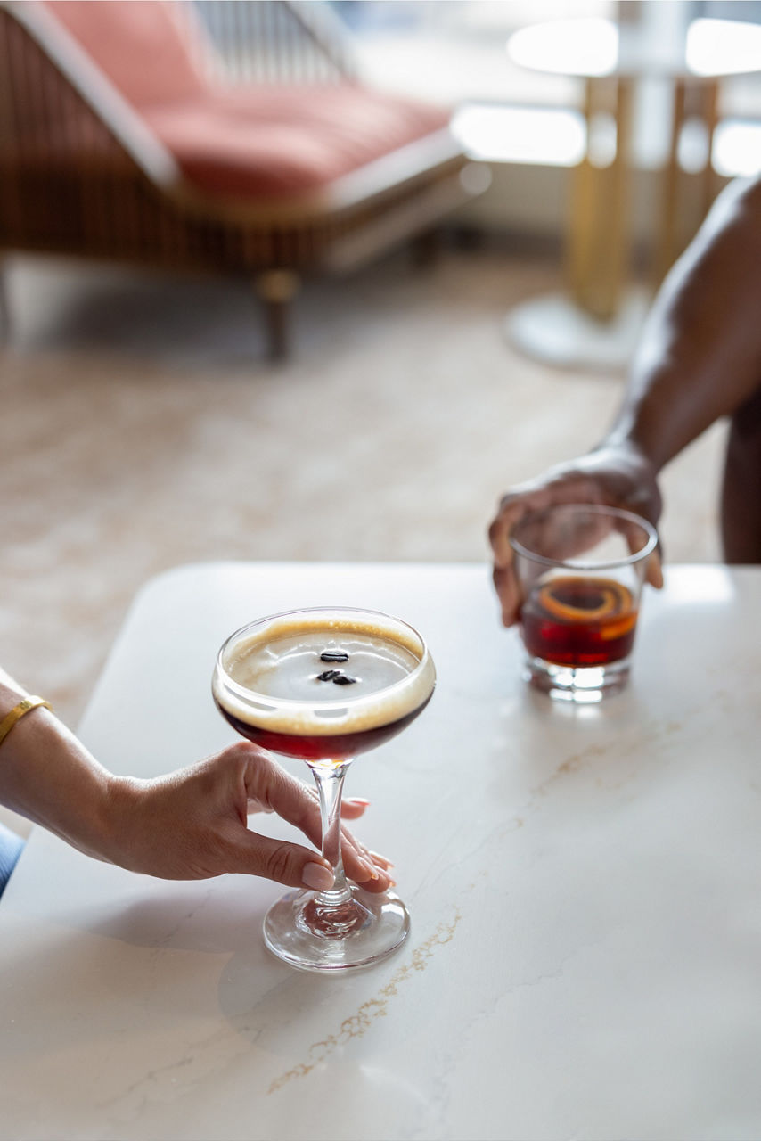 woman holding espresso martini man hoding old fashion cocktail rye bean star of the seas