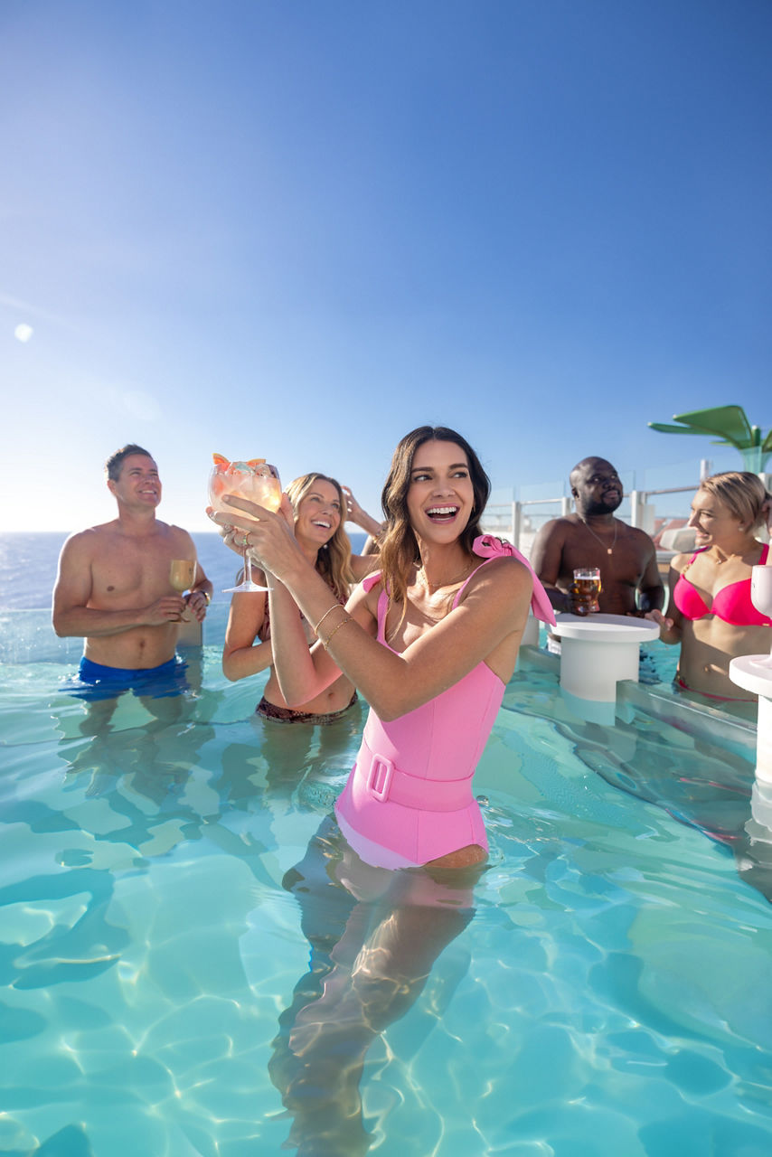 Woman smiling and having a cocktail at The Hideaway pool