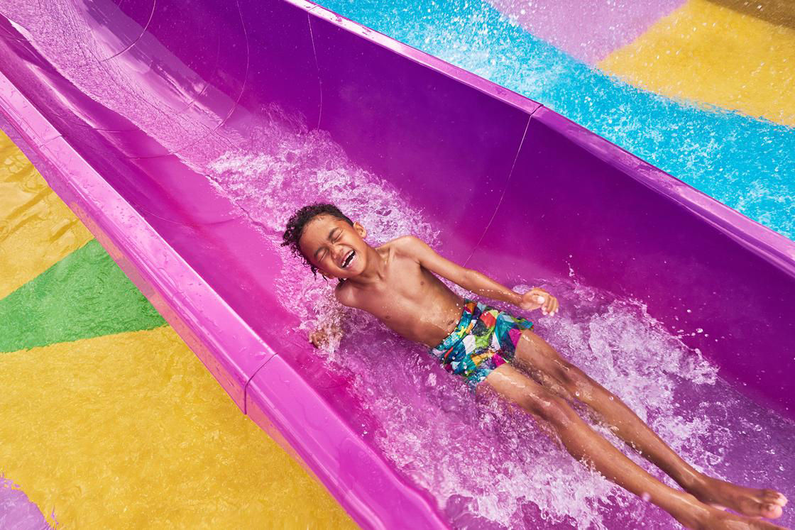 Boy sliding on splashaway slide