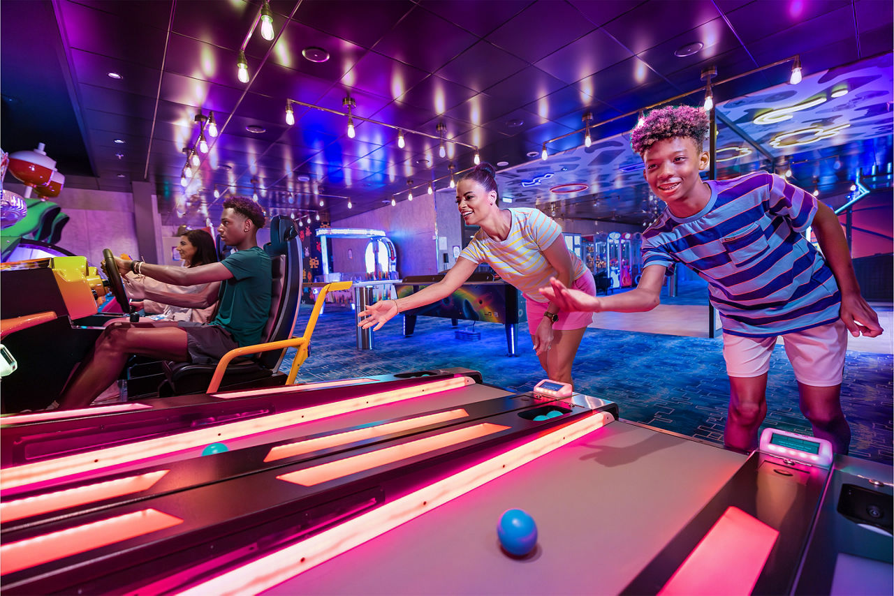 Mother and son playing skee-ball at the arcade