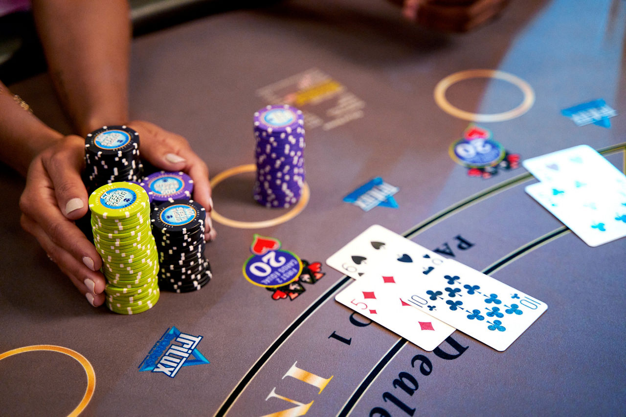Close-up of players hand pushing stacks of chips on table, Casino Royale