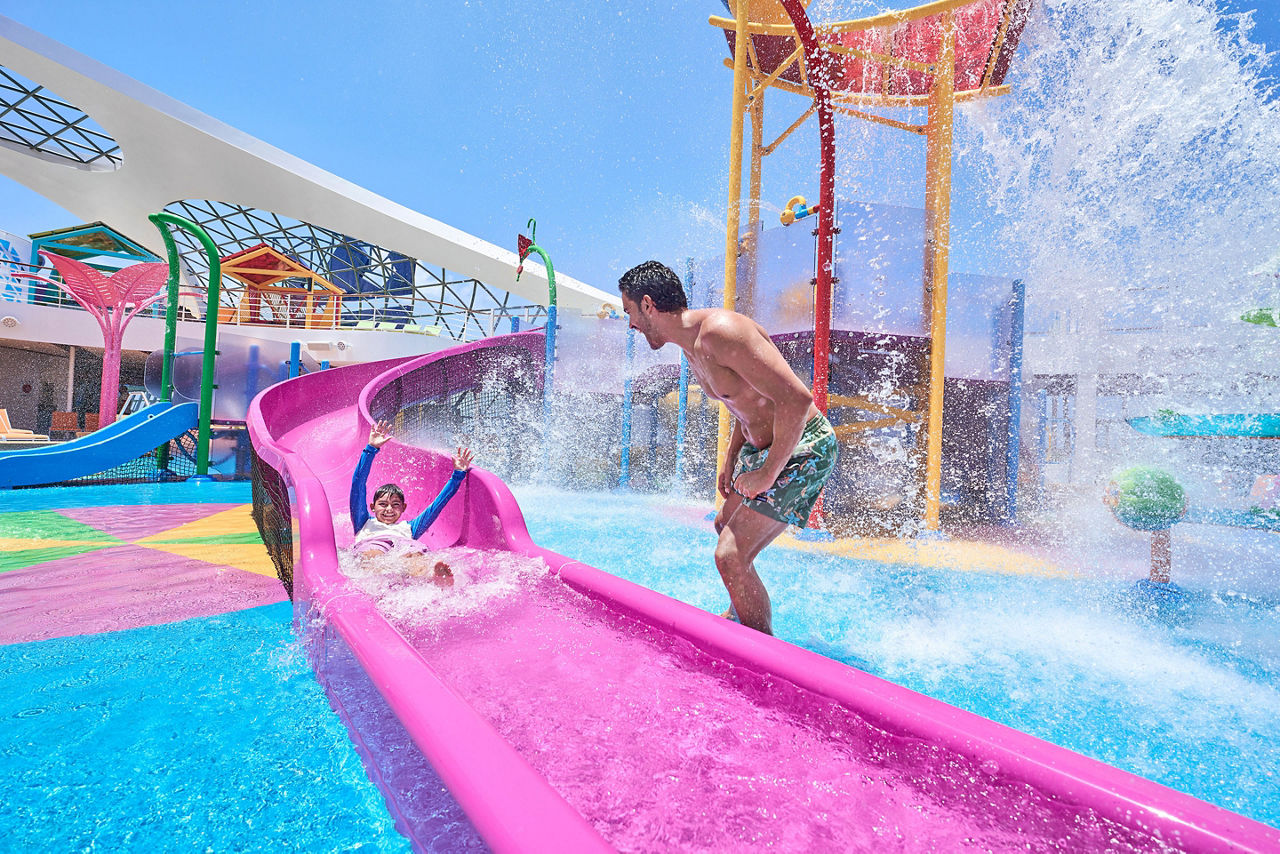 Dad greeting son coming down a slide at Splashaway Bay
