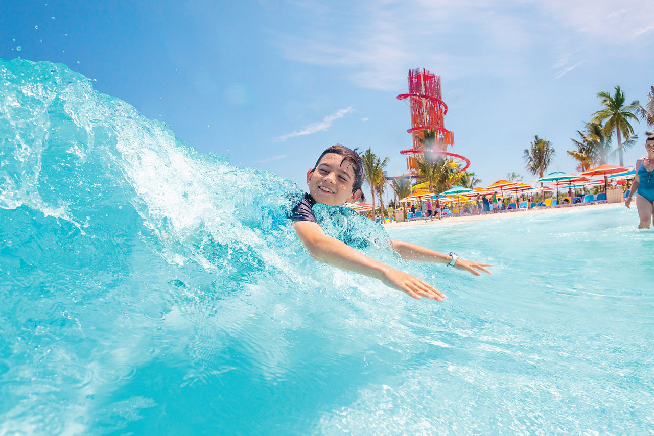 Little boy gliding on wave in Wave Pool, Perfect Day at CocoCay