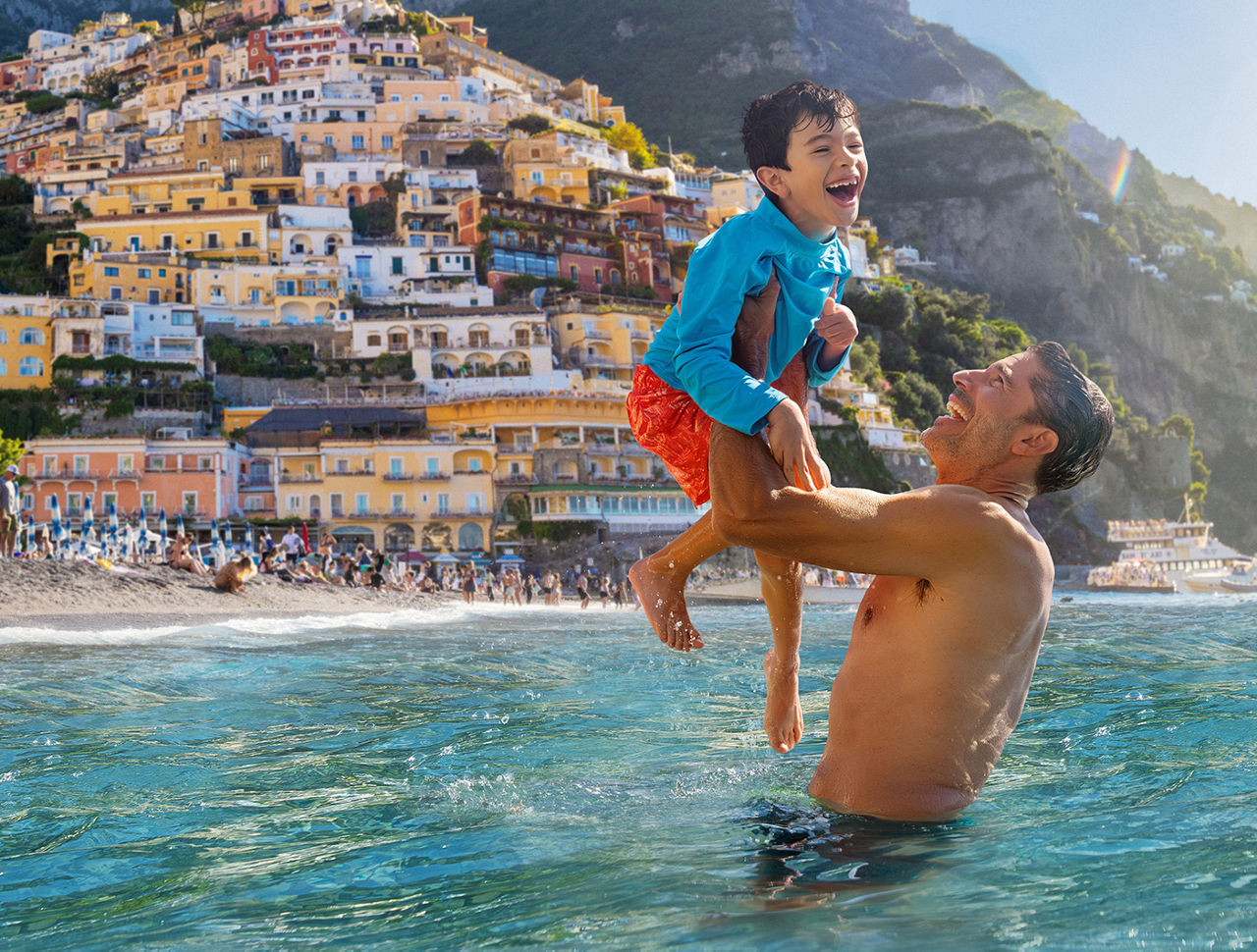 Father lifting son while in the ocean.