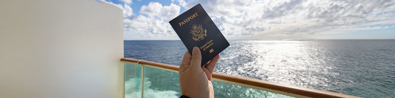 U.S. passport held above cruise ship balcony