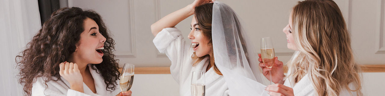 Ladies celebrating bachelorette party and drinking glasses of champagne