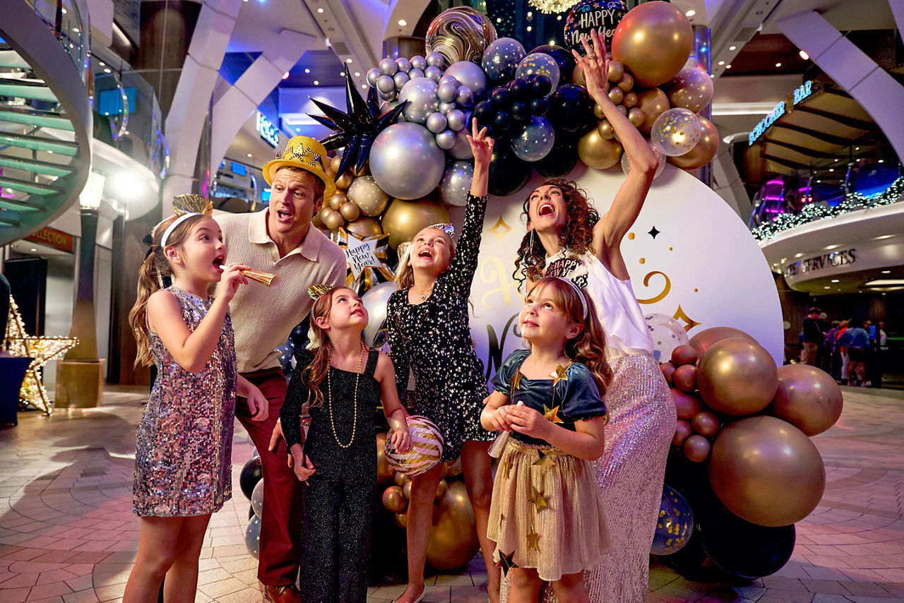 Family celebrating New Year’s Eve balloon drop on Royal Promenade.