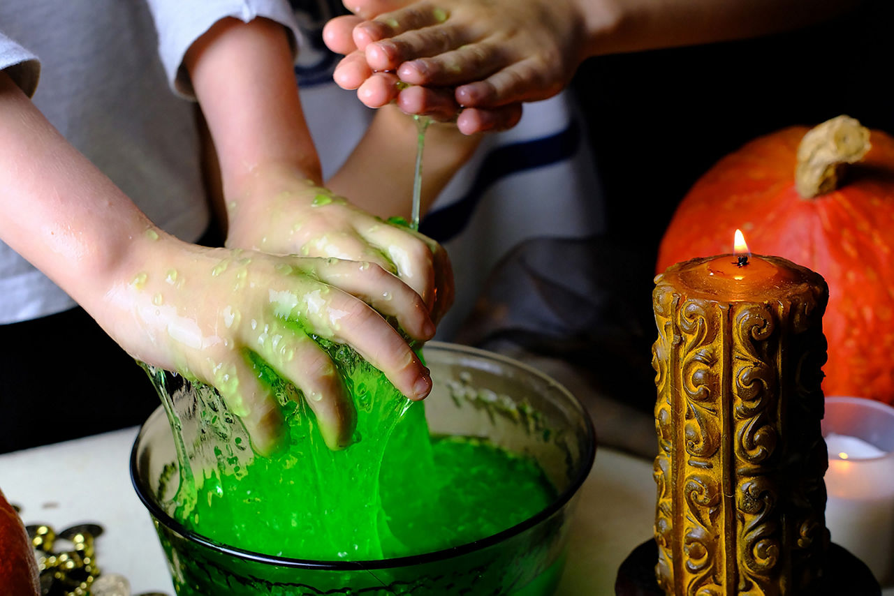 Hands holding green slime.