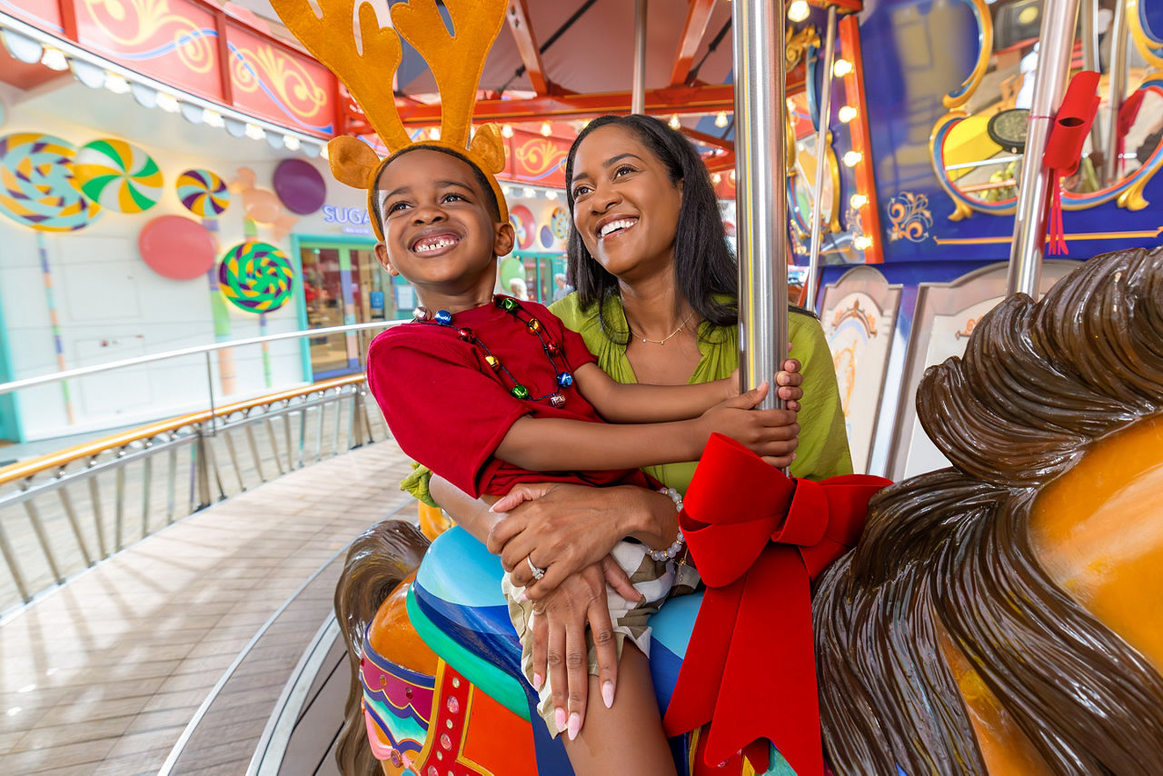 Mother and son riding the carousel at boardwalk on a holiday.