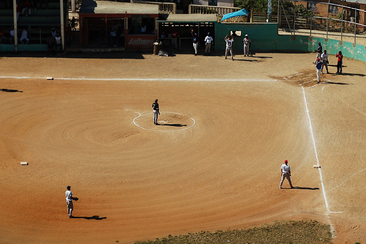 Aerial view of travelers and locals playing baseball. The Caribbean.