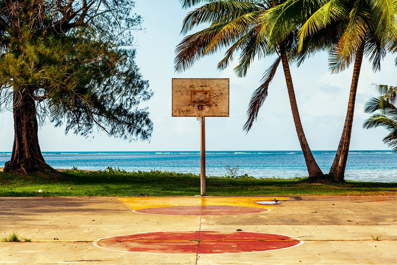 Basketball court with ocean and palms in background. The Caribbean.