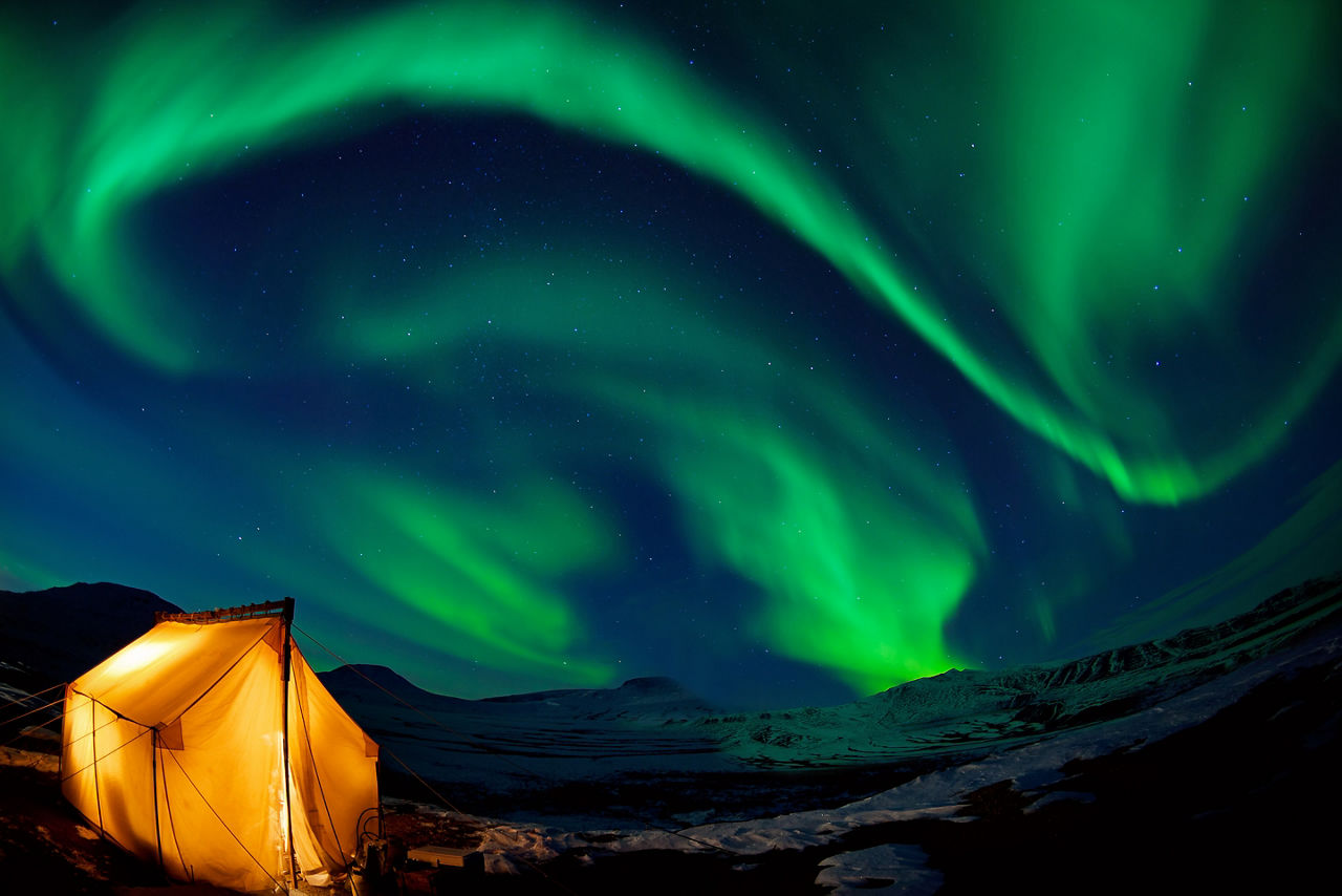Camping in the north with the northern lights overhead (Aurora Borealis)