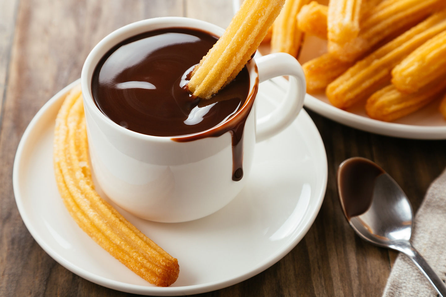End your Barcelona day with churros con chocolate — crispy, sugary dough dipped in rich, velvety chocolate. - Barcelona, Spain