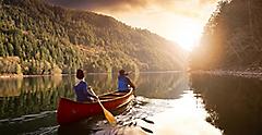 romantic couple canoeing toward a vacation sunset. Canada.