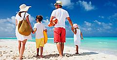 Family of four on a tropical summer beach getaway vacation. The Caribbean.