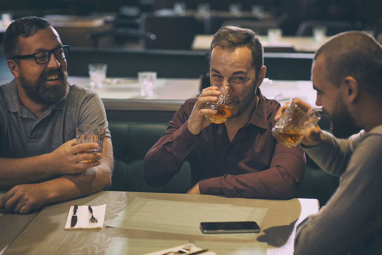 Friends drinking alchohol at the bar.