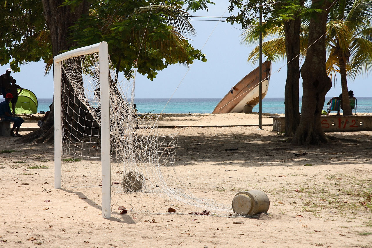 Soccer goal and ball on the beach near the water . The Caribbean