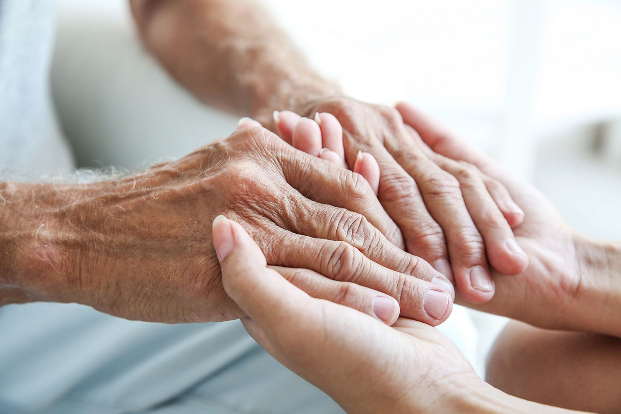 Volunteer with an Elderly Person who are Holding Hands