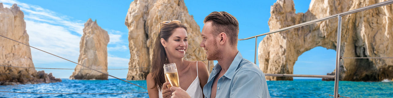 Couple enjoying drink on Catamaran deluxe coastal cruise Cabo San Lucas