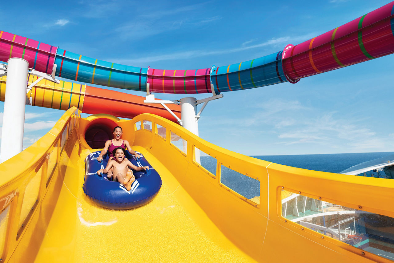 mother with kid enjoying blaster ride in water slide