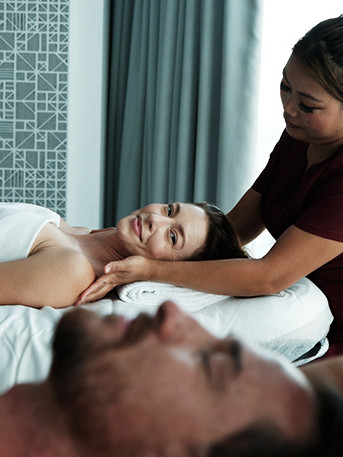 Tratamiento de masaje de spa de lujo con dos personas relajándose en camillas de masaje en una tranquila sala de bienestar