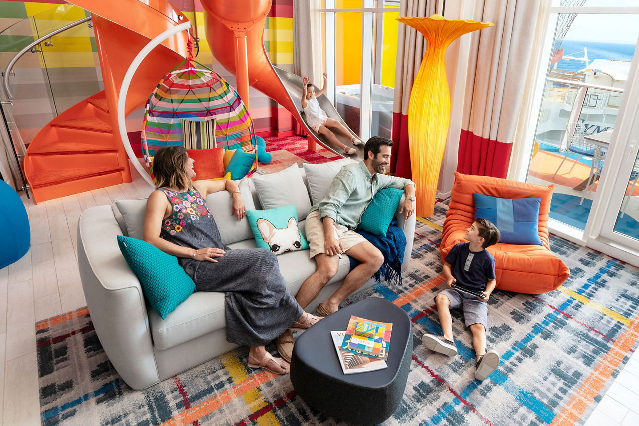 Oasis Class, Symphony Of The Seas, Family enjoying the Ultimate Family Suite while a girl goes down the slide