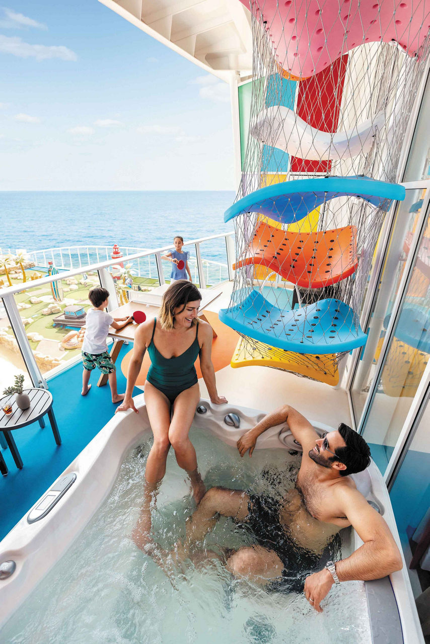 Oasis Class, Symphony Of The Seas, Family hanging out in the balcony with a jacuzzi in the Ultimate Family Suite.