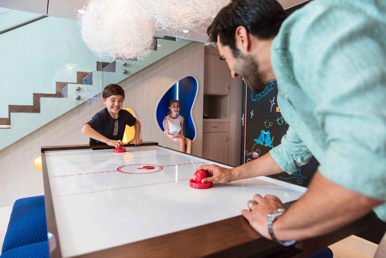 Oasis Class, Symphony of the Seas, Father and son playing air hockey in the Ultimate Family Suite