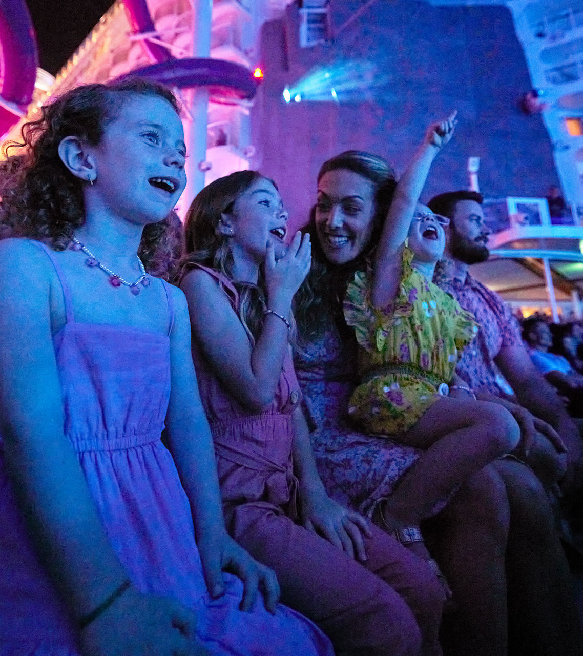 Oasis Class, Wonder of the Seas, Family watching a show at Aquatheater Performance on Wonder of the Seas
