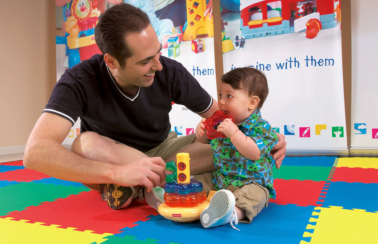 Father and son playing in a playroom onboard a family-friendly cruise.