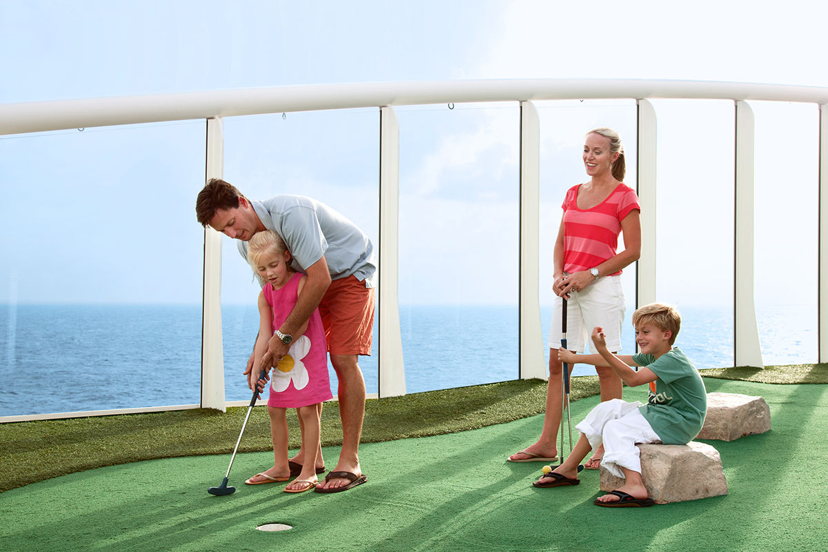 Family playing mini golf on a cruise. A cruise activity for families with children.