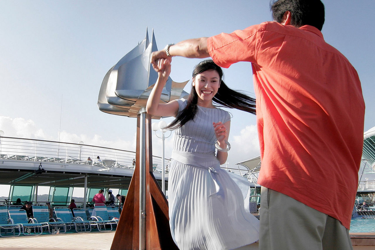 Trendy couple dancing at the pool deck. The Caribbean.