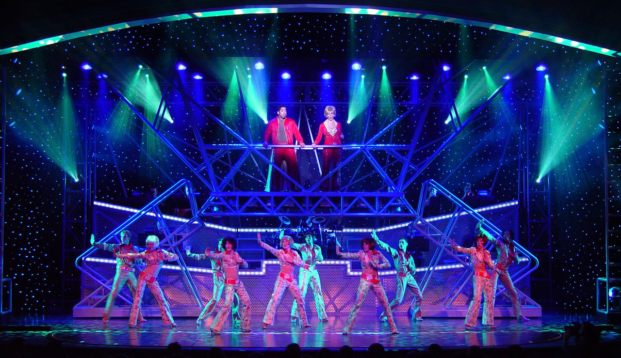 Performers in brightly lit stage during the All Access Cruise Show.