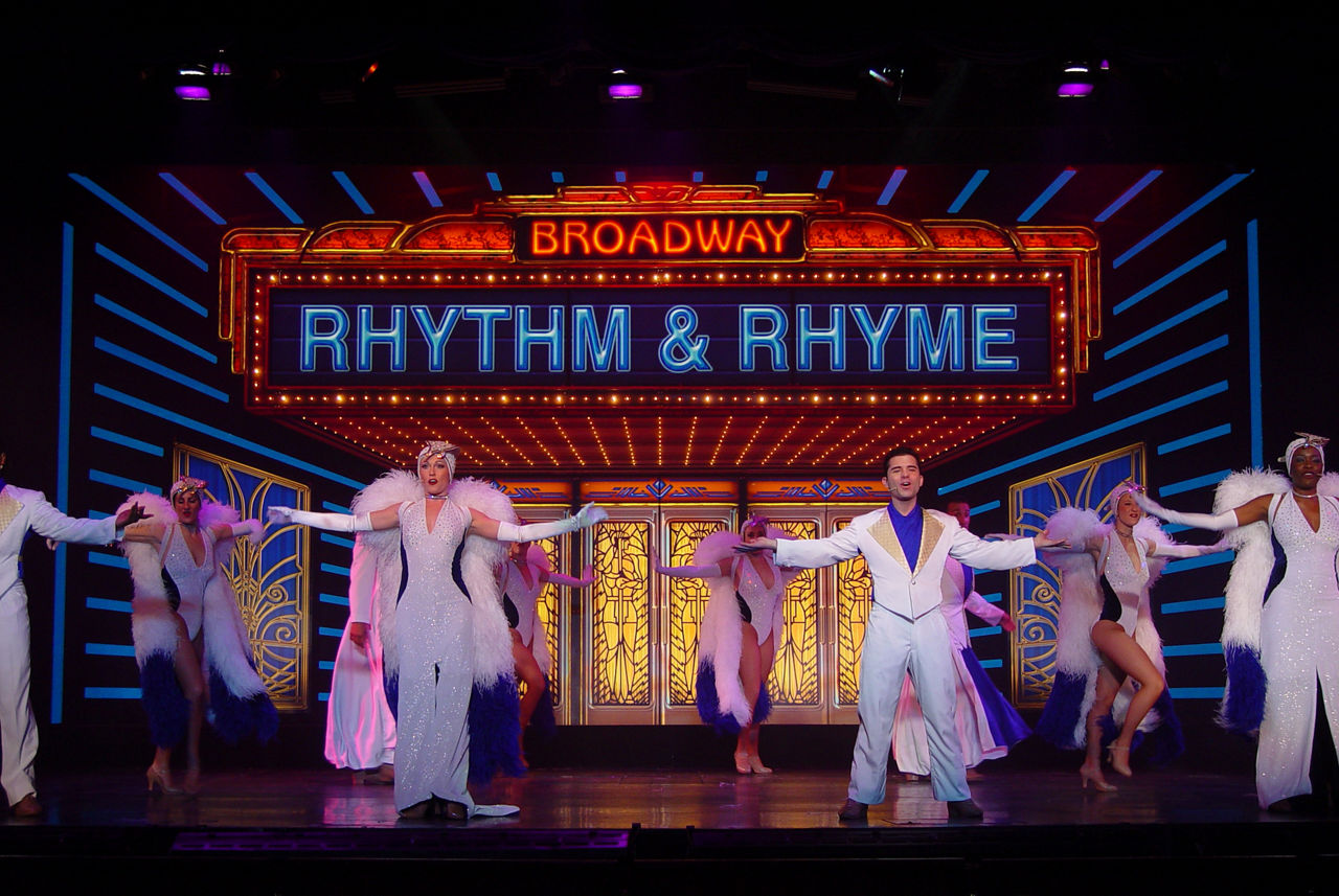 Performers dancing on stage for the Rhythm and Rhyme Cruise Show on Grandeur of the Seas