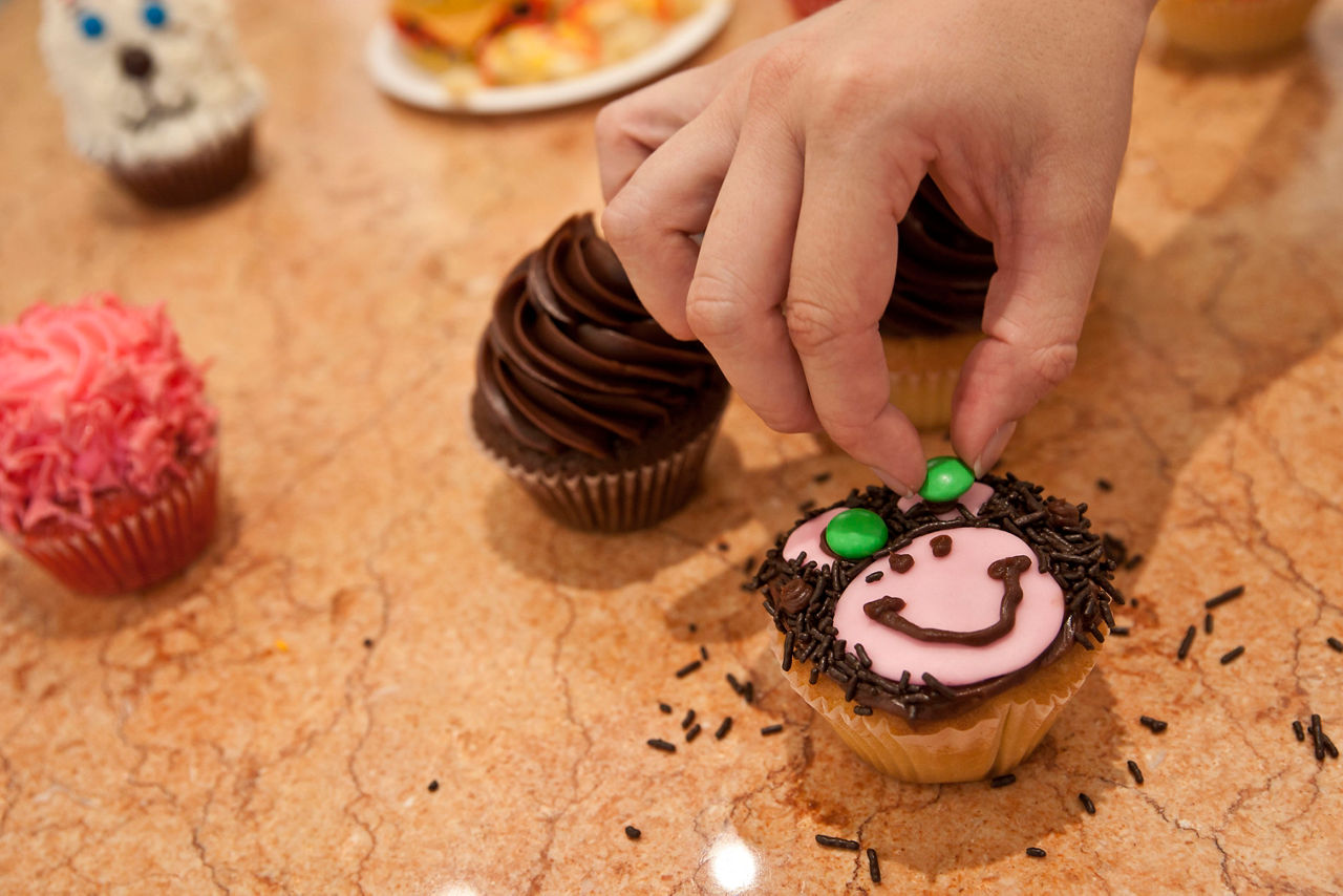 Woman Decorating her Cupcake as a Bear