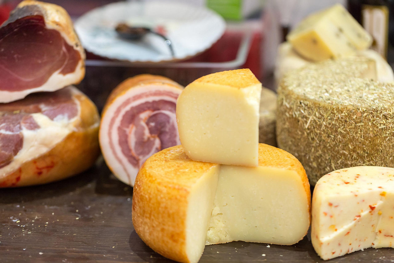 Different traditional and cheeses and ham at a shop in Bologna, Italy