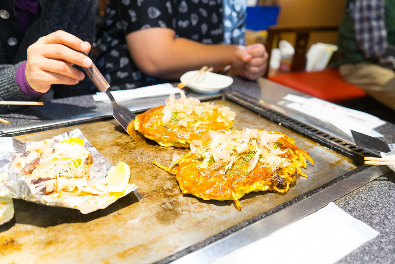 Hiroshima style Japanese pizzas on a flat top