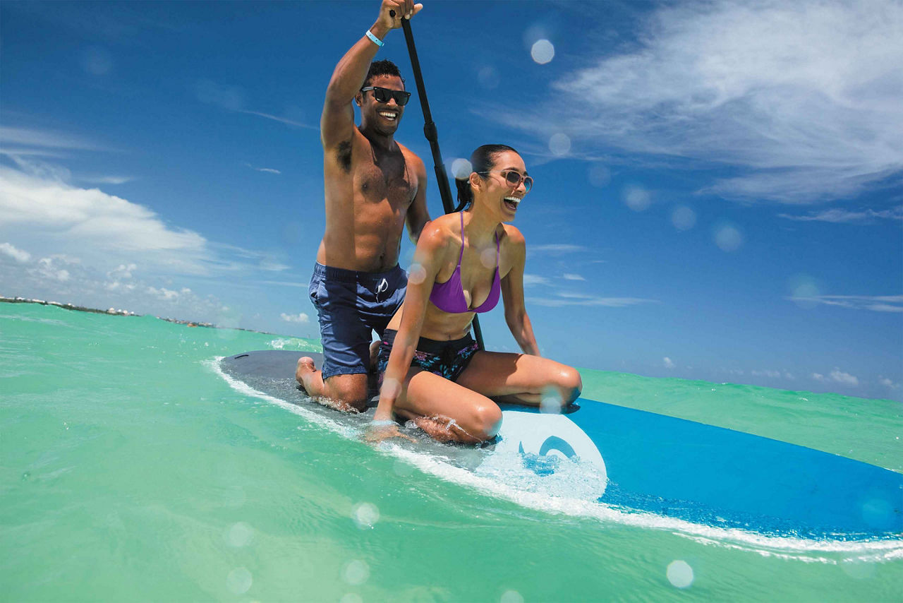 Couple Having Fun on a Paddle-board in the Water, Cozumel, Mexico 