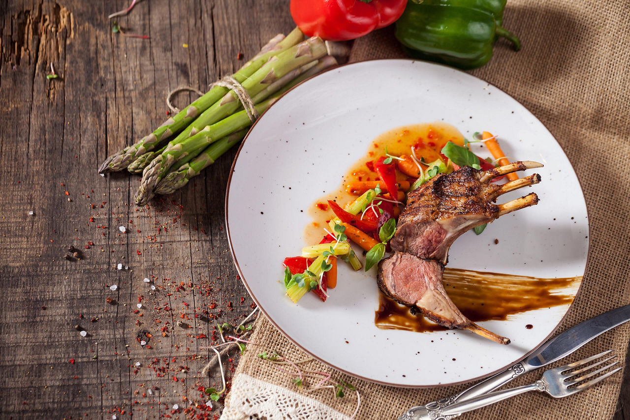 Lamb chops with vegetables served over a white plate