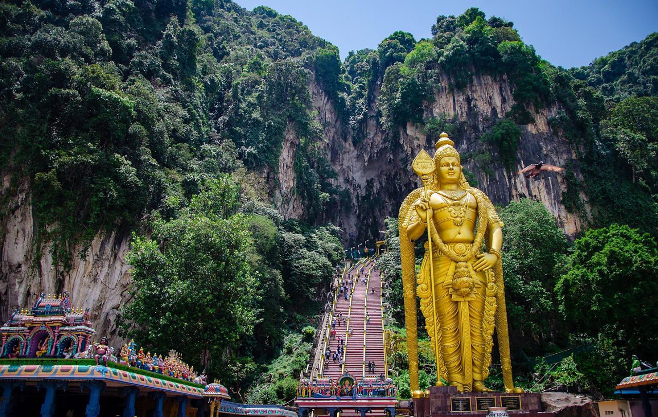 The Batu Caves with a gold statue of Lord Murugan at the entrance near Kuala Lumpur, Malaysia