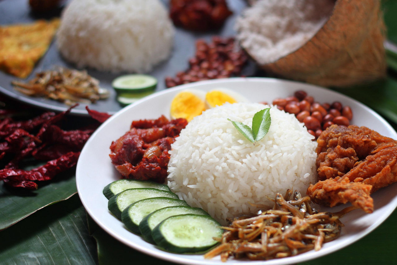 Nasi Lemak is a local cuisine in Langkawi, Malaysia consisting of rice with coconut cream, meats, and veggies